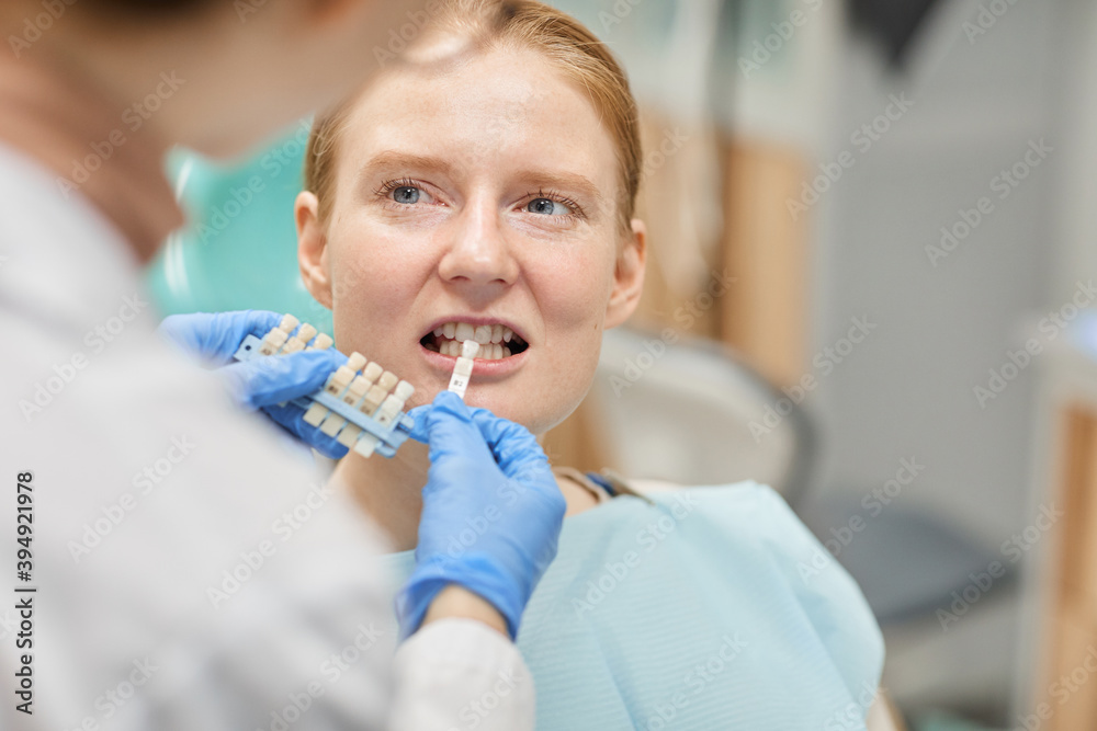 Patient showing her teeth while dentist choosing dental crowns for her Patient showing her teeth while dentist choosing dental crowns for her