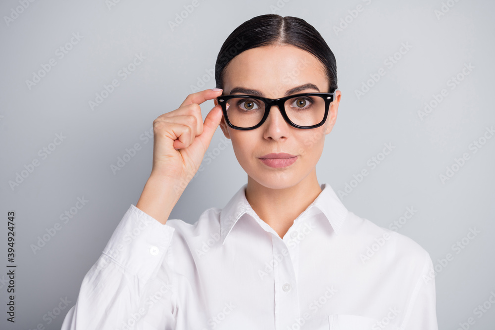 Photo of serious woman look camera fingers hold eyewear wear white shirt isolated grey color background Photo of serious woman look camera fingers hold eyewear wear white shirt isolated grey color background