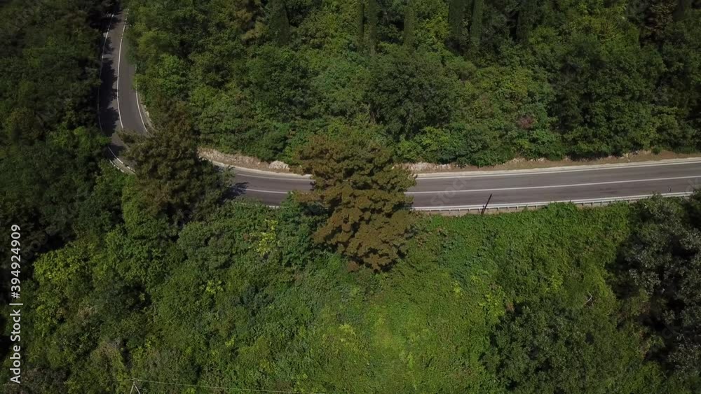 Aerial view from above of curve road with a car on the mountain with green forest in Russia Aerial view from above of curve road with a car on the mountain with green forest in Russia