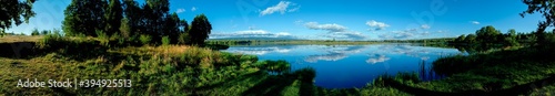 Panoramic view of a calm lake on a sunny summer day