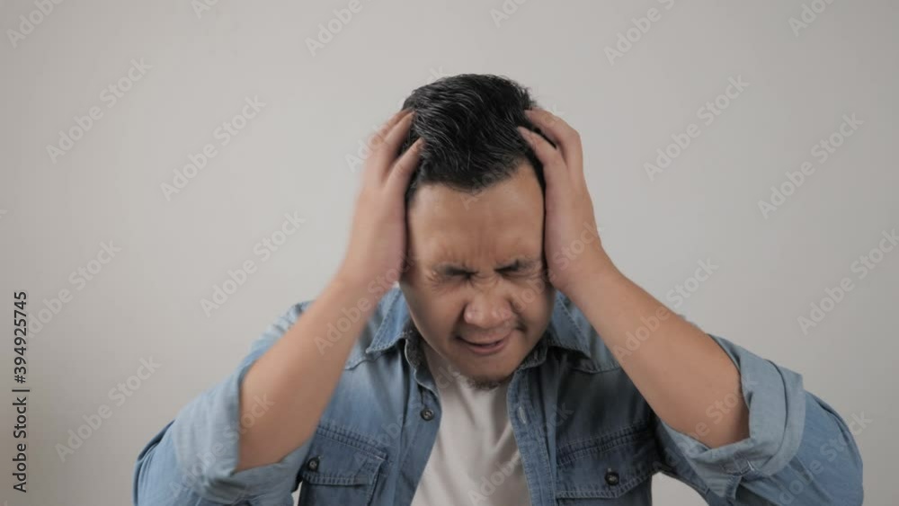 Young Asian man shouting loud because of anger. Concept of rage aggression mad frustration Young Asian man shouting loud because of anger. Concept of rage aggression mad frustration