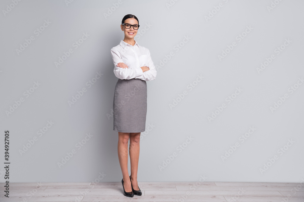 Full length photo of manager girl folded hands wear eyewear white shirt short skirt high heels isolated grey color background Full length photo of manager girl folded hands wear eyewear white shirt short skirt high heels isolated grey color background