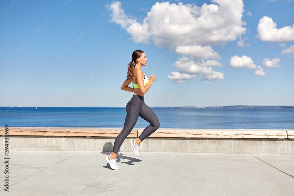 fitness, sport and healthy lifestyle concept - young woman running along sea promenade fitness, sport and healthy lifestyle concept - young woman running along sea promenade