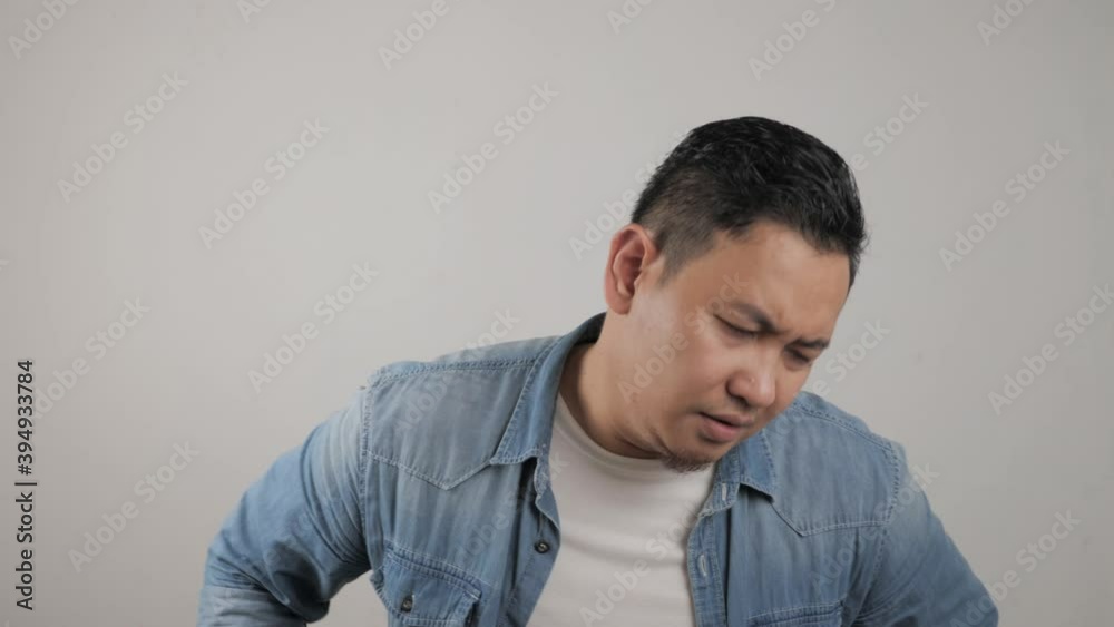 Asian man looking at camera with sad and regret expression, disappointed upset gesture.