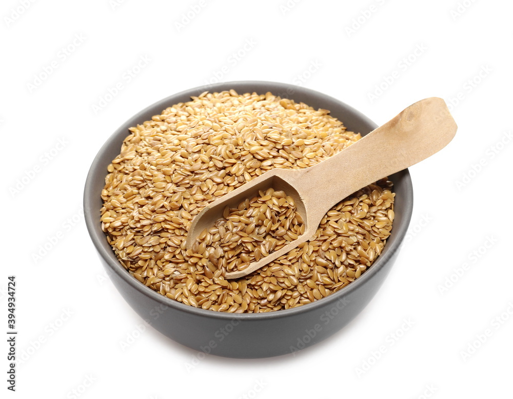 Golden linseed, linen seeds in porcelain bowl with wooden spoon isolated on white background Golden linseed, linen seeds in porcelain bowl with wooden spoon isolated on white background