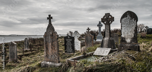 Ireland celtic cross at medieval church cemetery Old spooky cemetery . Haunted cemetery. Scary place. Old graves	