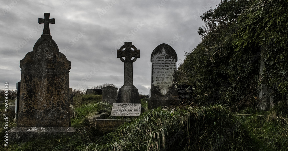 Ireland celtic cross at medieval church cemetery Old spooky cemetery . Haunted cemetery. Scary place. Old graves	