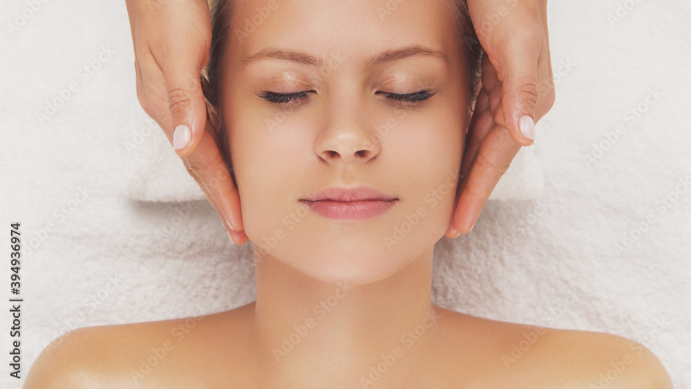 Naklejka premium Young, beautiful and healthy woman in massaging salon. Traditional face massage therapy and skin care.