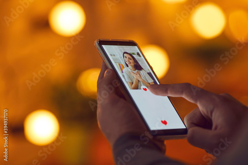 Male hands with smartphone choosing female profiles in online dating application