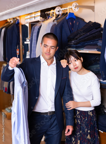 Seller helps buyer to choose a shirt in the store. High quality photo © JackF