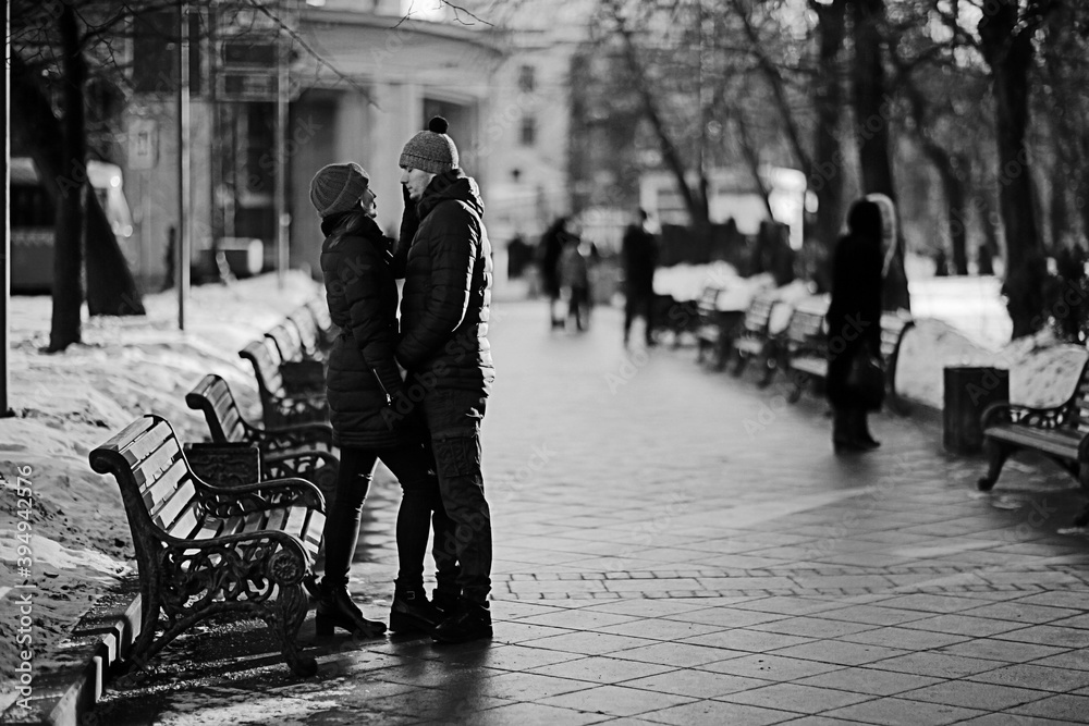 Fototapeta young man and woman hugging kissing outside