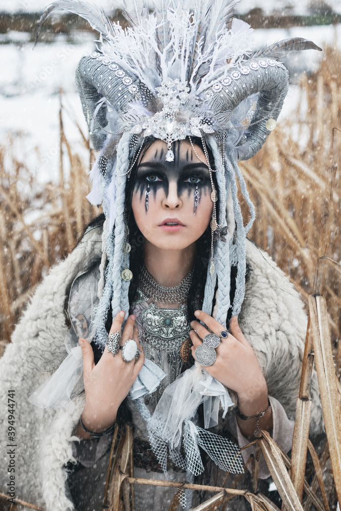 Φωτογραφία beautiful woman with black hair and fantasy make-up, in crown with braids, horns