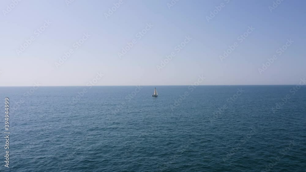 Aerial view of a sailboat alone in the Mediterranean, near Sète, south of France Aerial view of a sailboat alone in the Mediterranean, near Sète, south of France