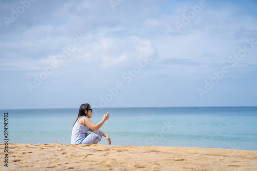 Woman taking selfie at the beach.