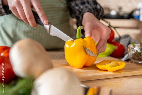 woman cutting vegetables.preparing healthy food. Yellow pepper. 