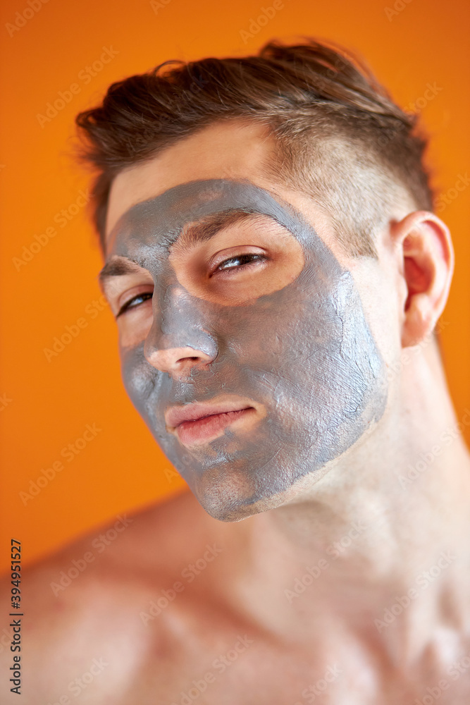 Obraz premium handsome young shirtless guy with cosmetic peel mask on face, caucasian male of caucasian appearace enjoy taking care of skin