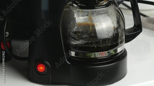 Drops fall into a transparent teapot.Black plastic case and red button.