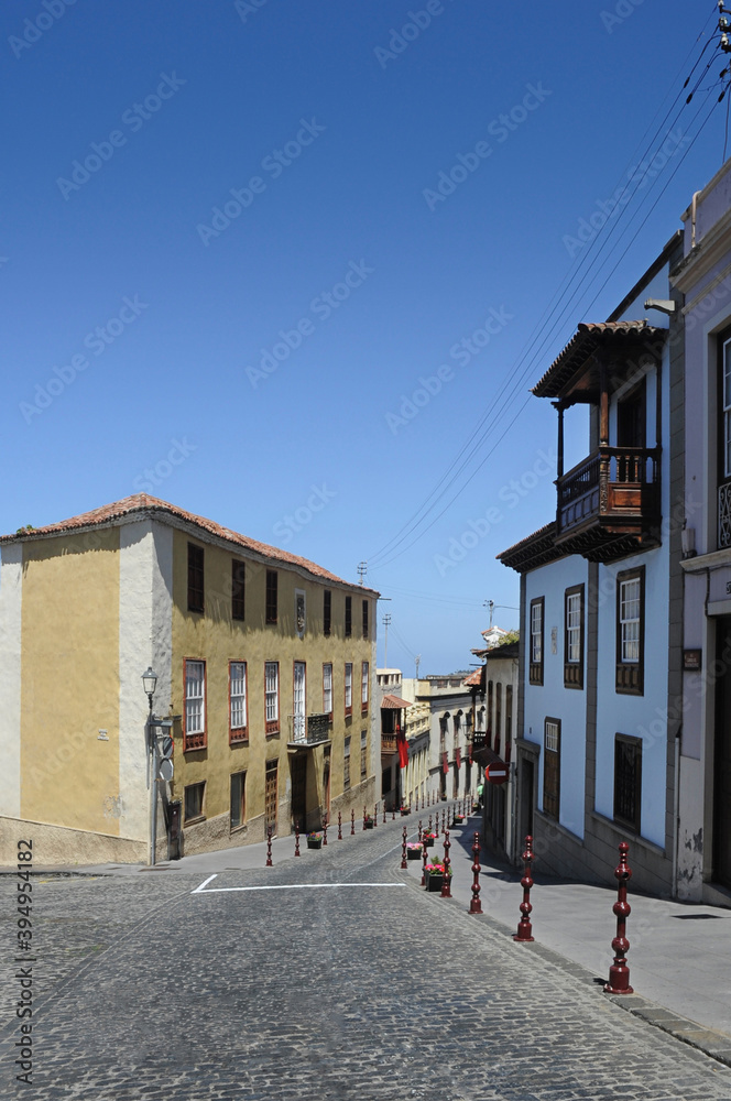 Quiet street with no people passing by on a sunny afternoon in La Orotava, beautiful charming traditional architecture with wooden balconies and old cobblestone road in Tenerife, Canary Islands, Spain