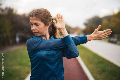 Fototapeta Naklejka Na Ścianę i Meble -  Beautiful adult woman is exercising outdoor on cloudy day in autumn.