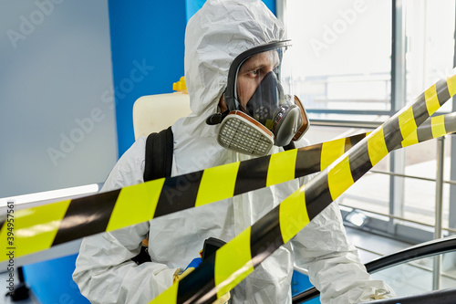 фотографія portrait of disinfectant male in suit and mask working in closed territory with