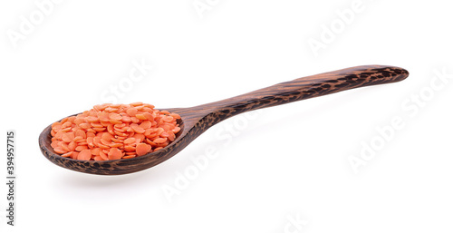 Red lentils in wood spoon on white background