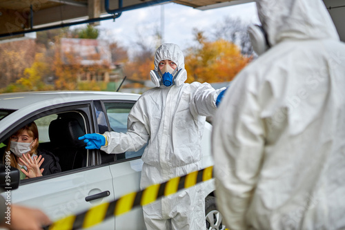 disinfectants check woman in car for covid 19 before granting entry clearance, outdoors