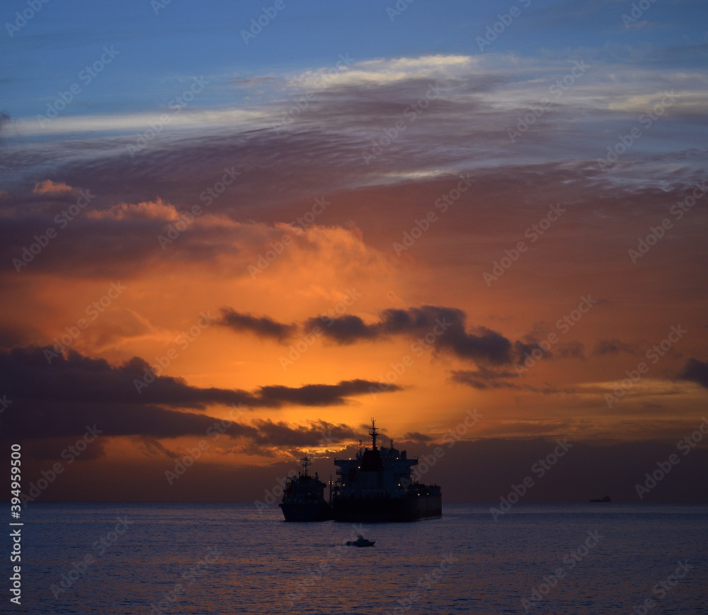 Obraz premium Dawn on the sea with dramatic sky, low clouds and ships