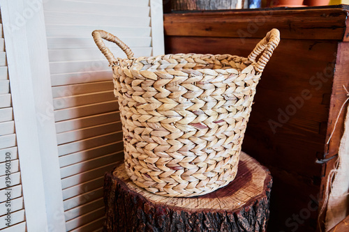 Style and decoration of the farmhouse hand-woven basket standing on a wooden stump. The concept of eco houses modern interior