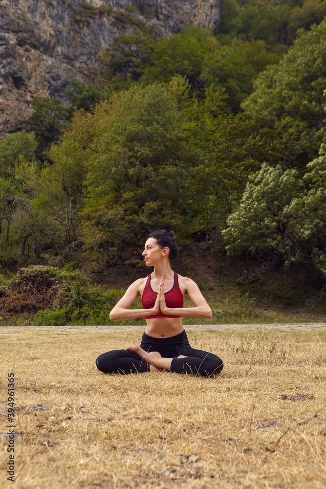 Yoga classes in nature. The concept of playing sports alone. Social exclusion. A woman does yoga in the mountains