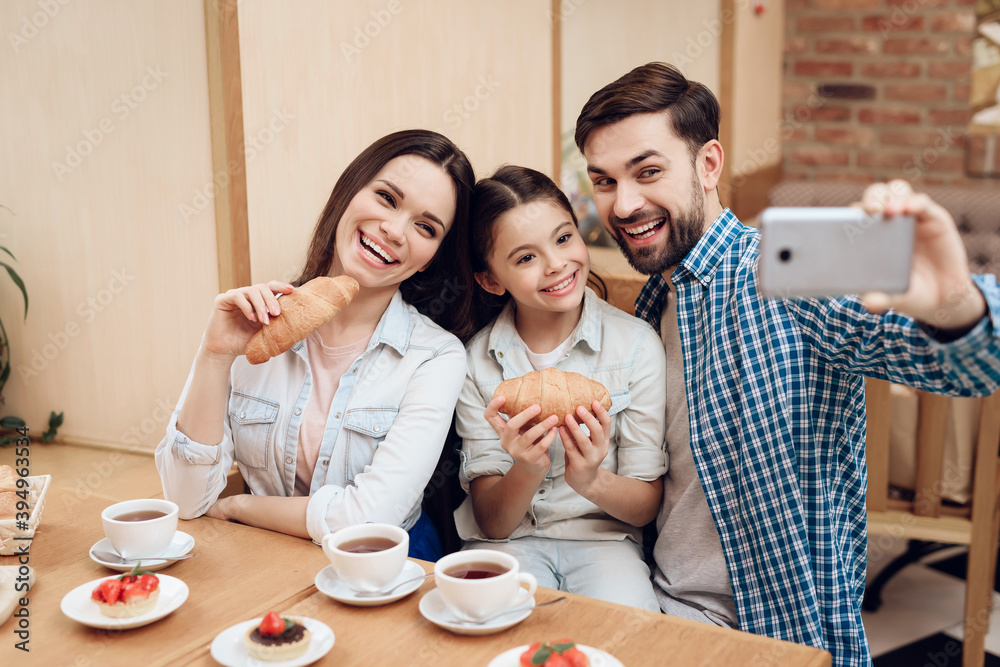 Young Happy Family Taking Selfie in Cafeteria. Young Happy Family Taking Selfie in Cafeteria.