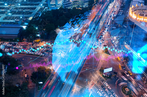Fototapeta Naklejka Na Ścianę i Meble -  FOREX and stock market chart hologram on aerial view of road, busy urban traffic highway at night. Junction network of transportation infrastructure. The concept of international trading.
