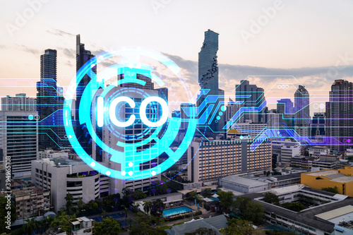 Hologram of glowing ICO icon, sunset panoramic city view of Bangkok, startup incubator of cryptocurrency projects in Asia. The concept of affordable opportunities in new era. Double exposure.