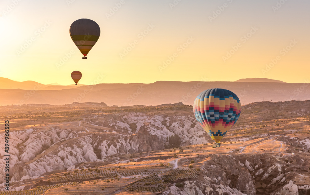 Hot air balloon flying over Cappadocia region, Goreme, Turkey. Great tourist attraction - sunrise balloning over Cappadocia valleys