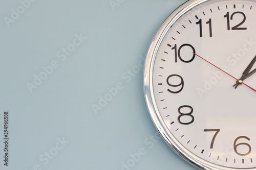 Simple wall clock hanging on a blue wall