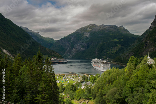  cruise ship docked at the end of the geiranger fjord, preparing travelers to disembark
