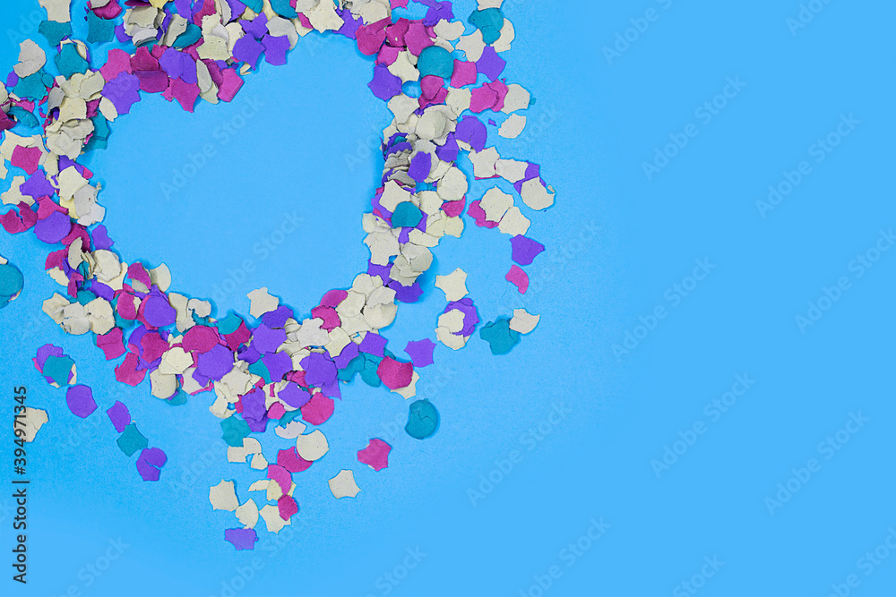 Valentine composition with a heart in confetti on blue background Valentine composition with a heart in confetti on blue background