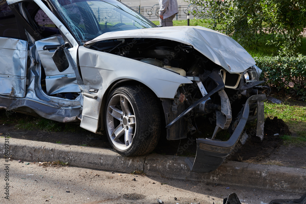 Silver car after a horrible crash accident. Front and side impact. Speeding concept photo. Life insurance. Accident beyond recovery.