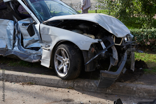 Silver car after a horrible crash accident. Front and side impact. Speeding concept photo. Life insurance. Accident beyond recovery.