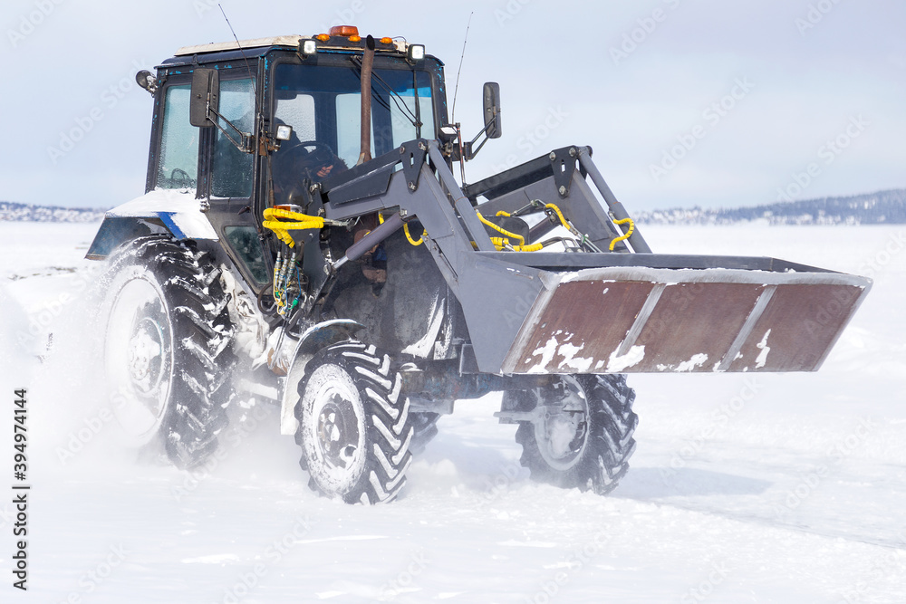 Snow removal vehicle on the road. Snow plow tractor is cleaning a city