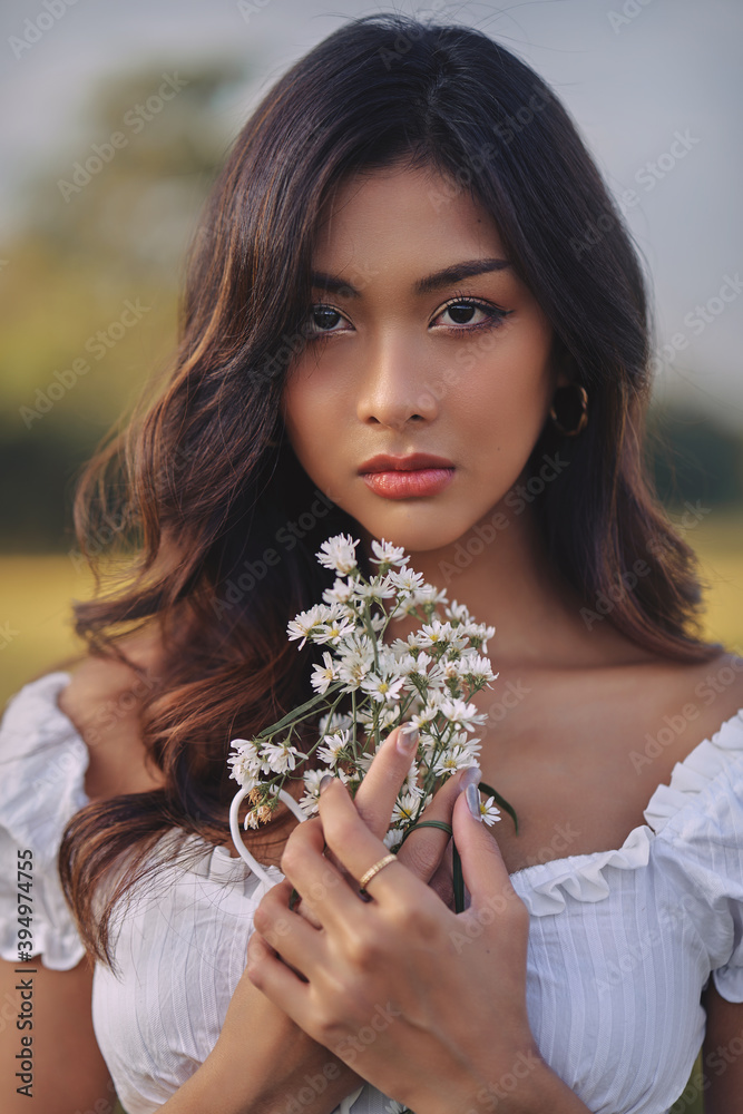 Lifestyle fashion portrait of stylish young asian woman wearing white outfit posing at the field