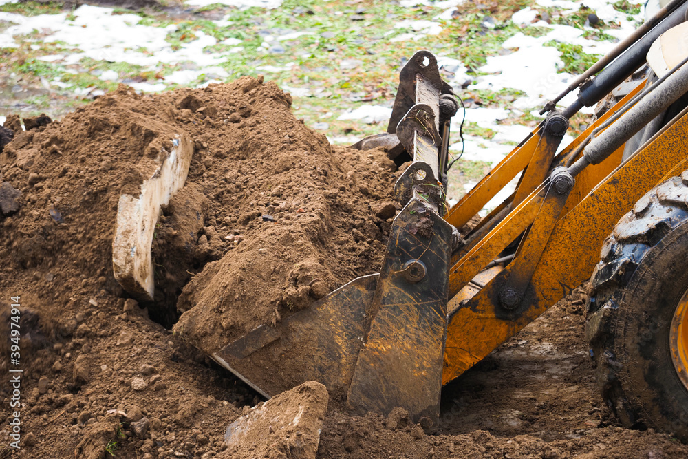 Fototapeta premium Yellow excavator on new construction site. Excavation, heavy bulldozer