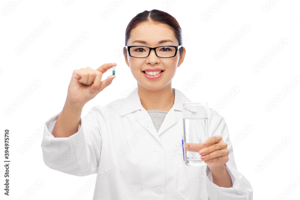 medicine, profession and healthcare concept - happy smiling asian female doctor or nurse pill and glass of water over white background
