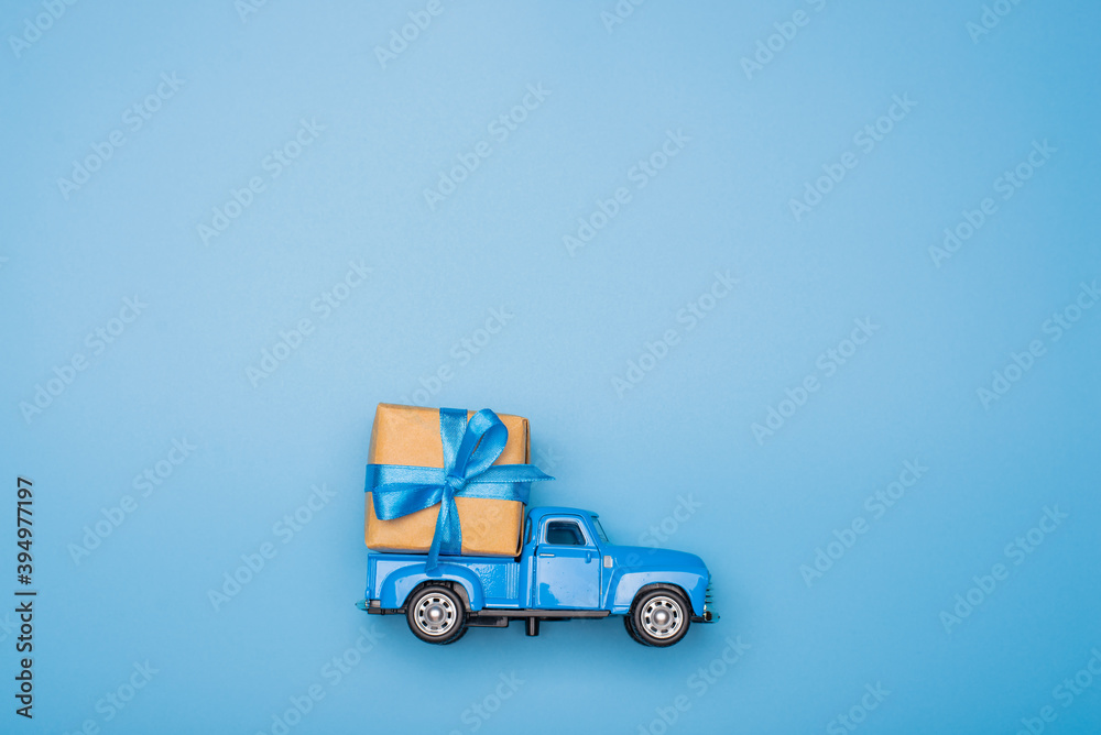 Blue retro toy car delivering gift box