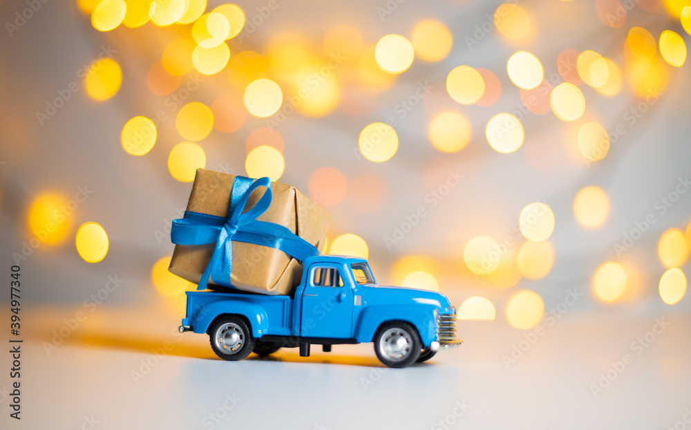 Obraz premium Blue retro toy car delivering gift box