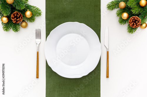 Christmas table setting with fir tree and gold toys on white background flat lay