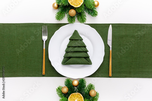 Christmas table setting with fir tree and gold toys on white background flat lay