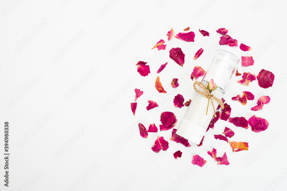 Natural herbal lotion concept. Cosmetic product bottle with rose blossom branch on a light pink background. Blank label for branding mock-up, copy space. Natural herbal lotion concept. Cosmetic product bottle with rose blossom branch on a light pink background. Blank label for branding mock-up, copy space.