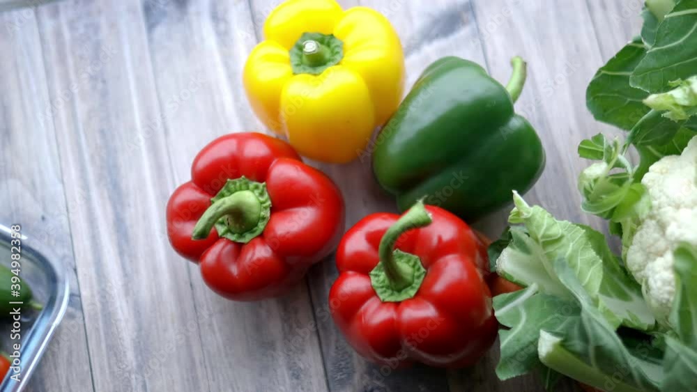 Fresh and colorful bell peppers and other vegetables on wooden table Fresh and colorful bell peppers and other vegetables on wooden table