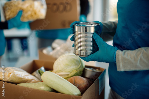 Close-up of a volunteer packing food in donation box. photo