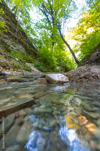 beautiful mountain stream flowing down the stones in the forest